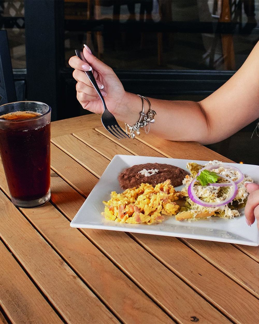 Desayuno con huevos, chilaquiles y bebida en la terraza de Kingans Colón